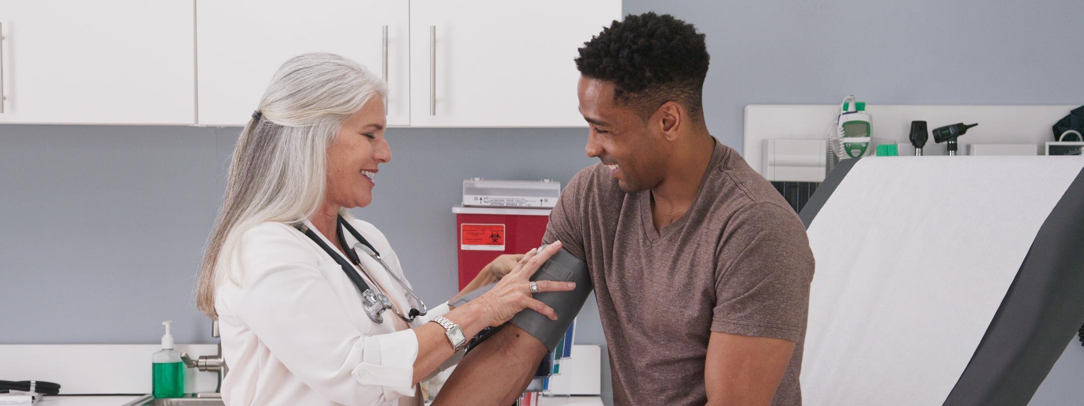 Woman taking blood pressure of patient